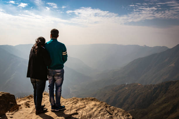 istock couple watching the beautiful mountain range from edge of mountain 1220888348