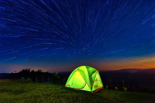 istock Star circles above the night mountain forest and a glowing camping tent 1220888390
