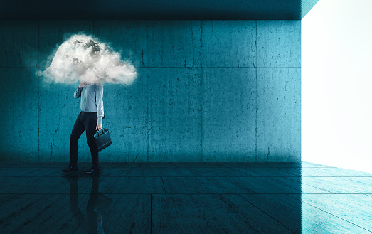 Businessman walking on a modern blue background with a his head in a cloud.