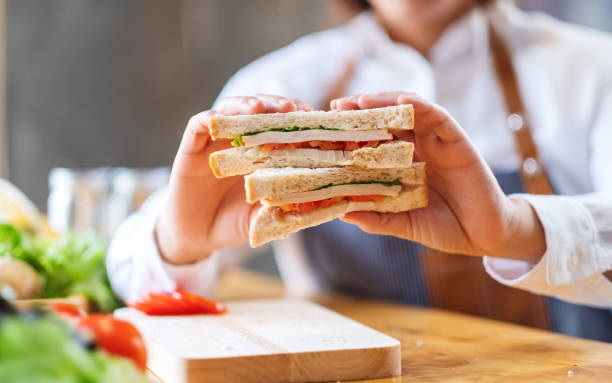 istock a female chef cooking and showing a whole wheat sandwich in kitchen 1220890151