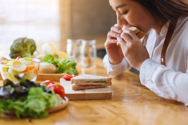istock a female chef cooking and eating a whole wheat sandwich in kitchen 1220890221