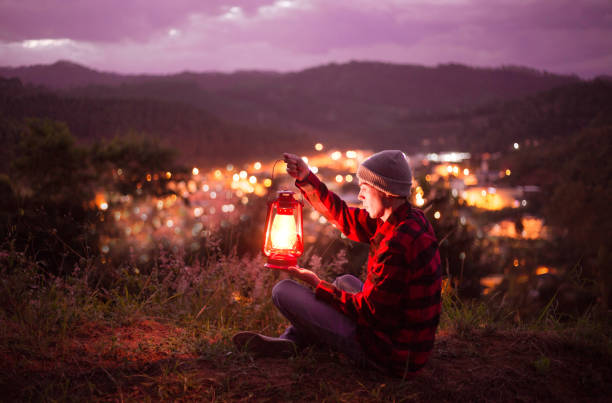 istock Kerosene lamp lit and city lights with twilight sky 1220893380