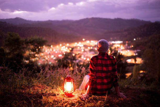istock Kerosene lamp lit and city lights with twilight sky 1220893548