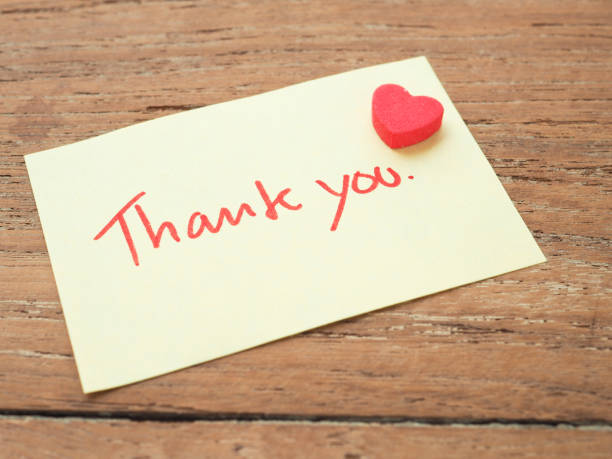 istock Thank you handwriting on post-it notes with red heart on a wooden background 1220893697