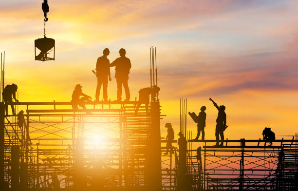 istock Silhouette of Engineer and worker on building site sunset in evening time. 1220894447