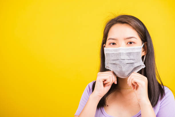 istock woman wearing face mask protective against coronavirus showing demonstrating correct step 1220895878