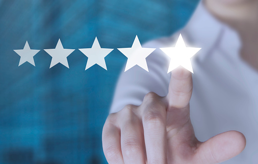 Hand touching five star symbol to increase rating of company concept