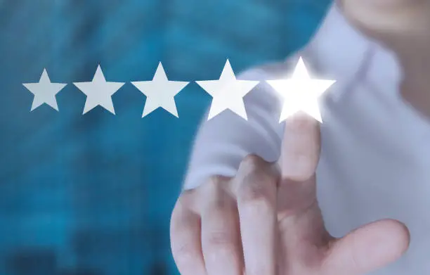 Hand touching five star symbol to increase rating of company concept