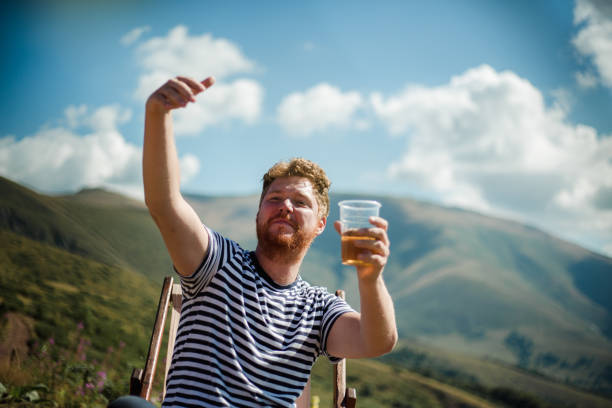 istock He hiker is resting on top of the mountain with a beer 1220904295