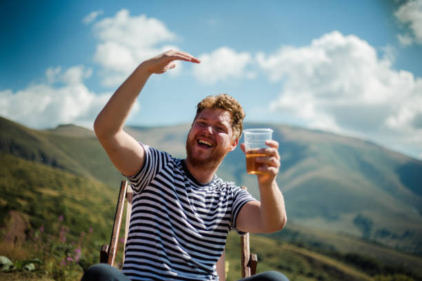 istock He hiker is resting on top of the mountain with a beer 1220904307