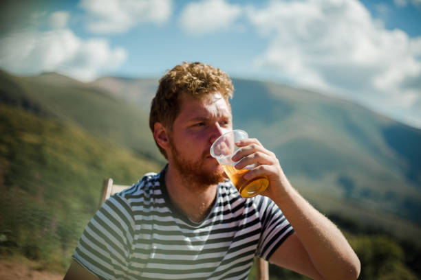 istock He hiker is resting on top of the mountain with a beer 1220904367