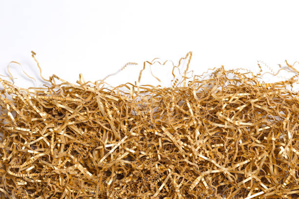 istock Golden shredded paper for gifting, shipping and stuffing on white background 1220906991