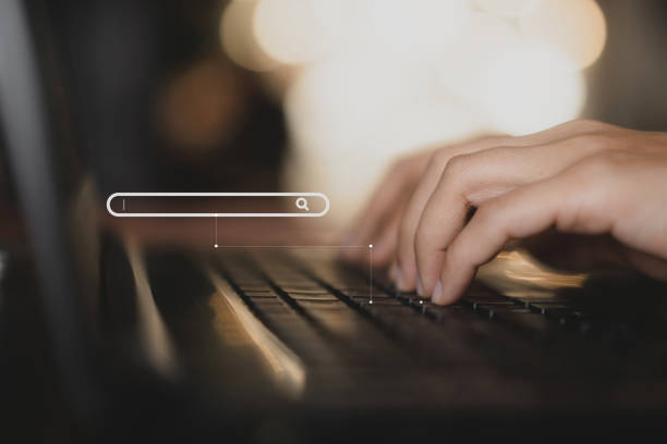 mão de mulher usando laptop de teclado com ícone de barra de pesquisa na mesa de madeira na cafeteria. - web link - fotografias e filmes do acervo