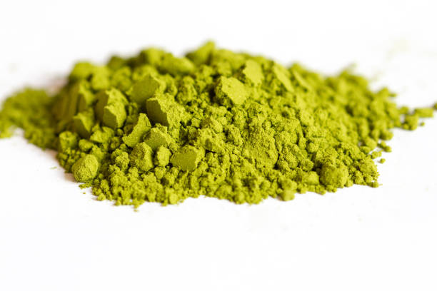 istock Powdered green matcha tea on a white isolated background close-up. Texture of matcha tea macro background. Copy space. Top view. 1220908018