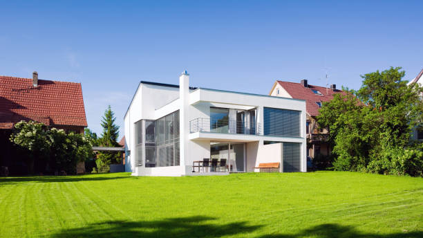 Modern Architecture Home Green On Green Summer Meadow Modern Architecture Sustainable Green Home Panorama with Summer Garden Meadow Front Yard under blue cloudless summer sky. apartment balcony garden stock pictures, royalty-free photos & images