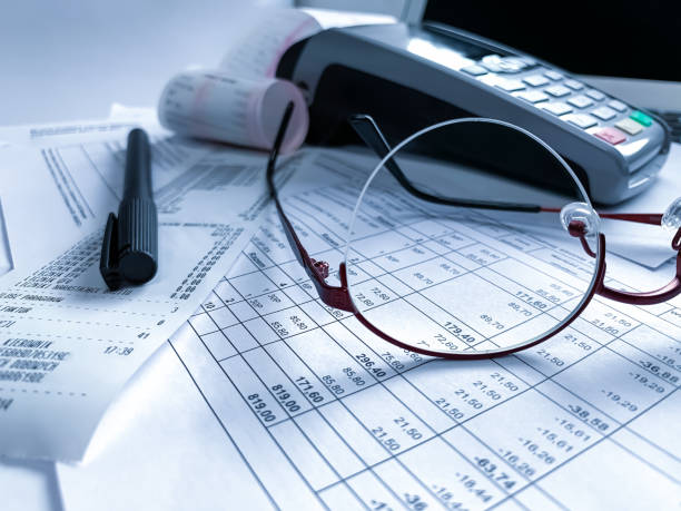 istock round metal glasses, a cash register and a pen on the table with documents.  accounting, document management. business 1220909262