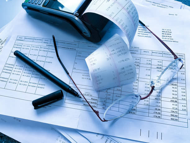 istock round metal glasses, a cash register and a pen on the table with documents.  accounting, document management. business 1220909270