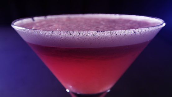 Cosmopolitan or cosmo, is a cocktail made with vodka, triple sec, cranberry juice, and freshly squeezed or sweetened lime juice served in a martini glass isolated on black background.