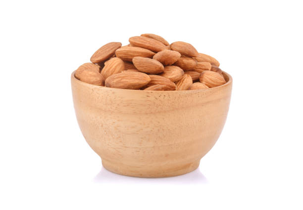 istock Almonds in wooden bowl isolated on white background. 1220916723