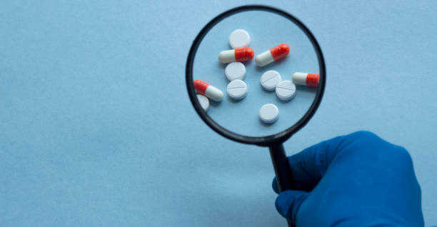 istock Pharmacist or expert on pharmaceutical inspection identifies pills. Testing, verification and determining pharmaceutical counterfeiting or fakes of medicines and medicinal substance quality concept 1220921065