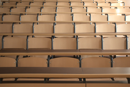 Shot of well organized empty university classroom seats due to the global pandemic after the cancellation of schools