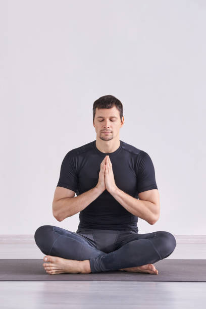 istock Man yoga class. Black wear. Calm relax pose 1220921631