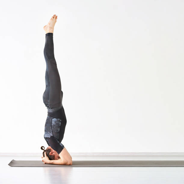 istock Man yoga class. Black wear. Calm relax sirsasana pose 1220921634
