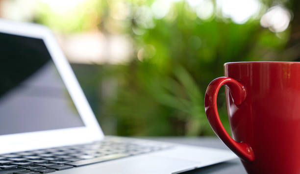 istock Coffee in red cup with computer laptop at the background 1220922225