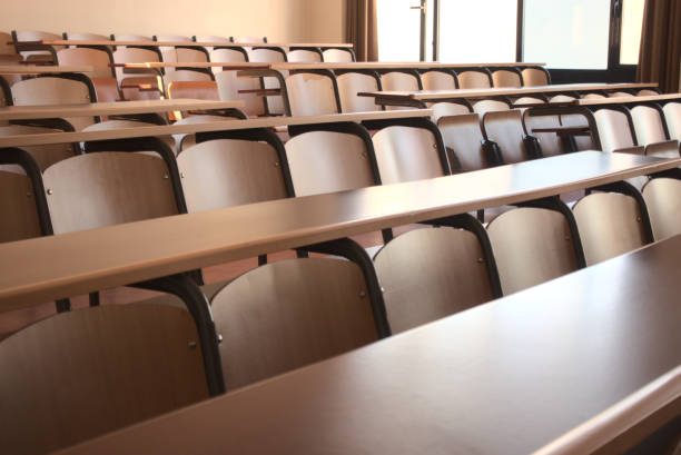 Shot of an empty classroom after the cancellation of schools regarding covid 19 Shot of an empty university classroom after the cancellation of schools regarding covid 19 lecture hall photos stock pictures, royalty-free photos & images
