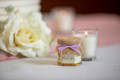 Handout gift and lit candle on a table at a wedding ceremony