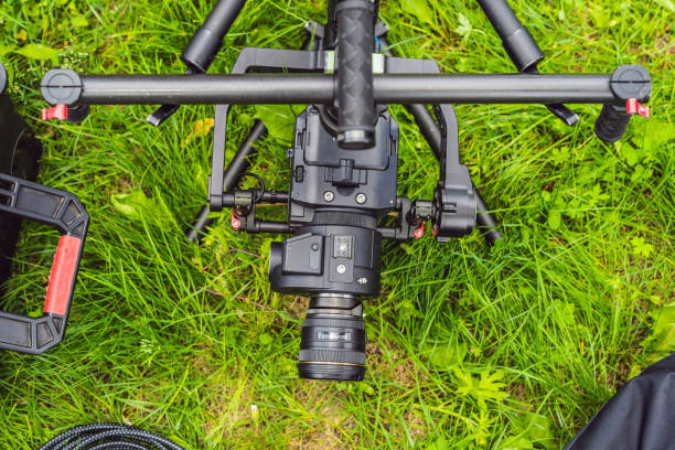 istock Cameraman setting up heavy duty professional 3-axis gimbal stabilizer for cinema camera 1220923492