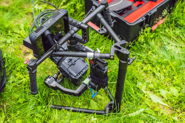 istock Cameraman setting up heavy duty professional 3-axis gimbal stabilizer for cinema camera 1220923493