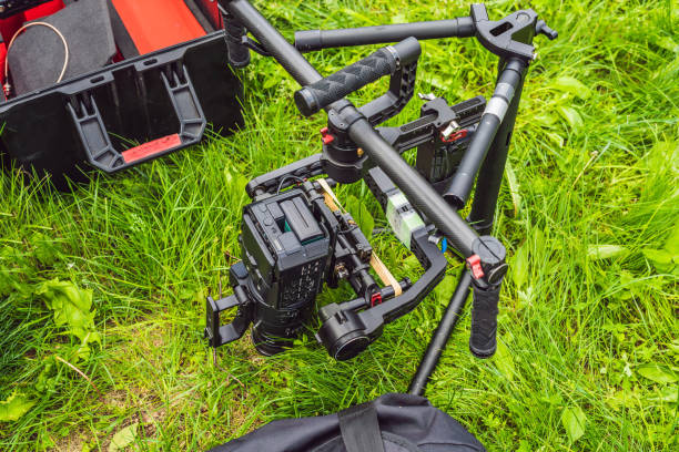 istock Cameraman setting up heavy duty professional 3-axis gimbal stabilizer for cinema camera 1220923500