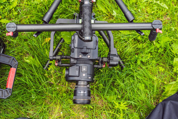 istock Cameraman setting up heavy duty professional 3-axis gimbal stabilizer for cinema camera 1220923510