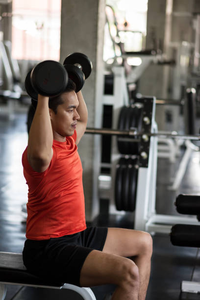 istock Strong man exercise biceps by dumbbell in gym 1220924484