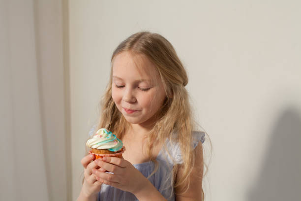 istock Beautiful little girl eats sweet candy cake 1220926085