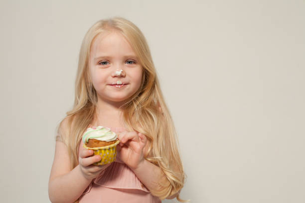istock Beautiful little girl eats sweet candy cake 1220926207