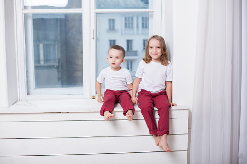 boy with girl brother and sister sitting next to each other in the room