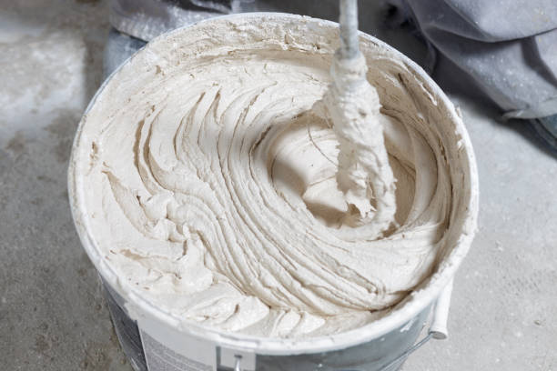 istock Builder mixing plaster in a bucket using an electric mixer 1220935366