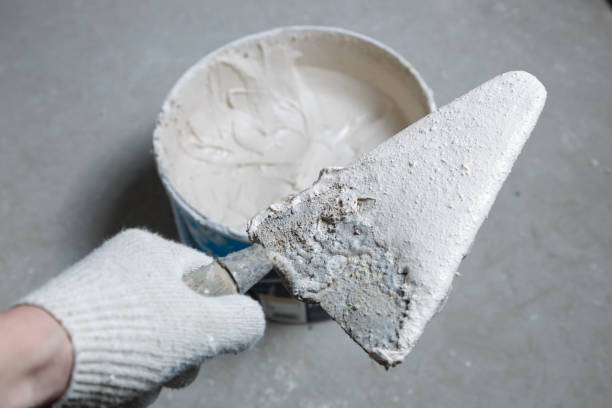 worker hands holding a spatula with wet concrete - plasterer plaster wall dirty imagens e fotografias de stock