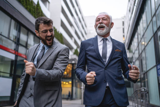 istock Excited business partners dancing outdoors 1220936228