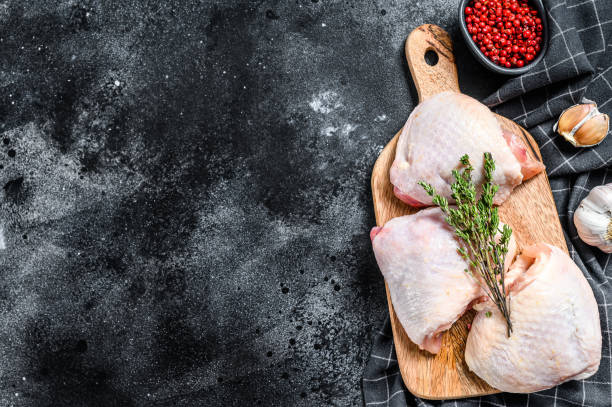 istock Raw chicken thigh, organic poultry meat. Black background. Top view. Copy space 1220938157