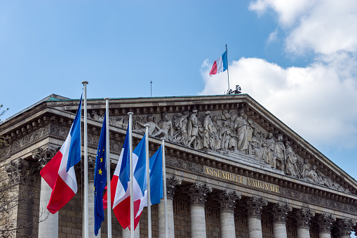 Paris, France: French and European Union flags in the wind in front of National Assembly