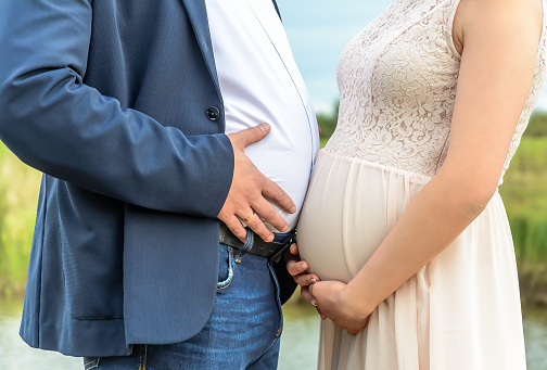 Photo of a pregnant woman and a potbellied man