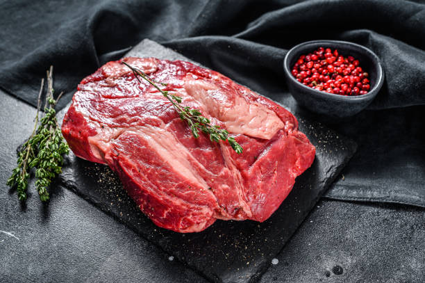 istock Fresh Raw meat Prime Black Angus Chuck roll steak.  Black background. Top view 1220940364