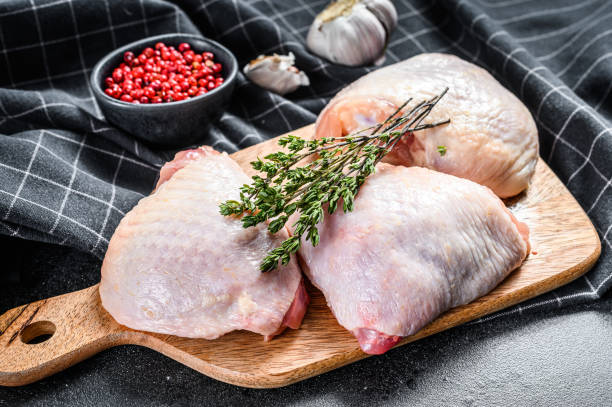 istock Raw chicken thigh, organic poultry meat. Black background. Top view 1220940818