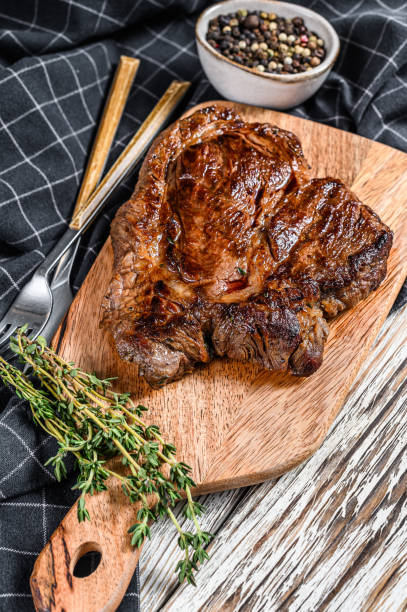 istock Cooked grilled Chuck eye roll steak on a chopping Board. White background. Top view 1220941720