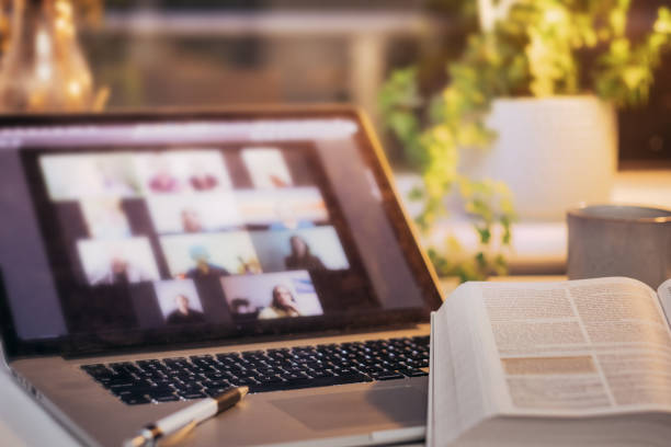 Bible Study Videoconference Computer and bible on a desk at home with a videoconference on the screen church stock pictures, royalty-free photos & images