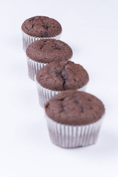 istock Brown chocolate muffins arranged over white background 1220944547