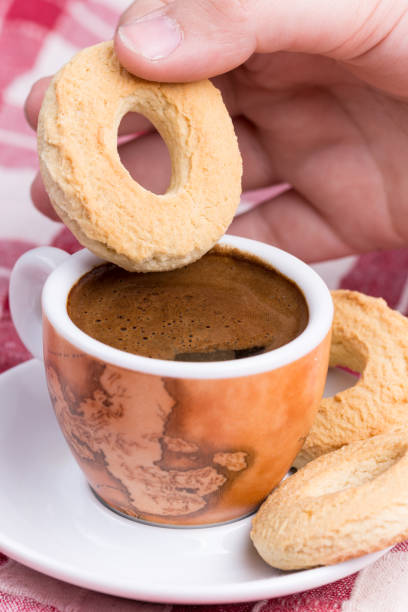 istock Hand dipping round cookie in to coffee cup 1220945673